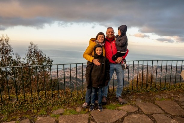 a man and a woman standing in front of a fence