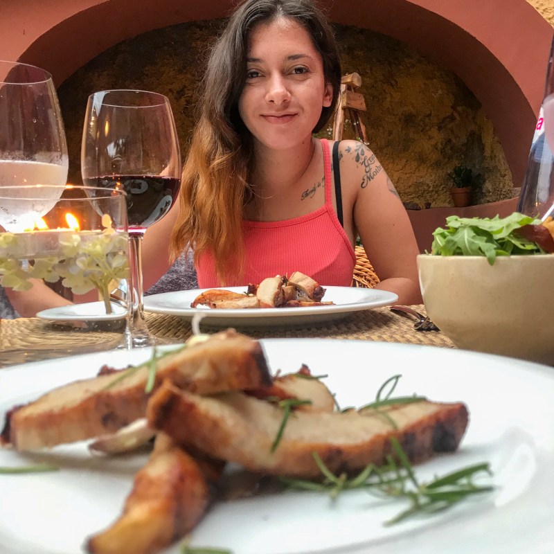 a woman sitting at a table with a plate of food