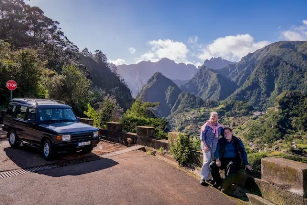a person sitting on the side of a mountain road